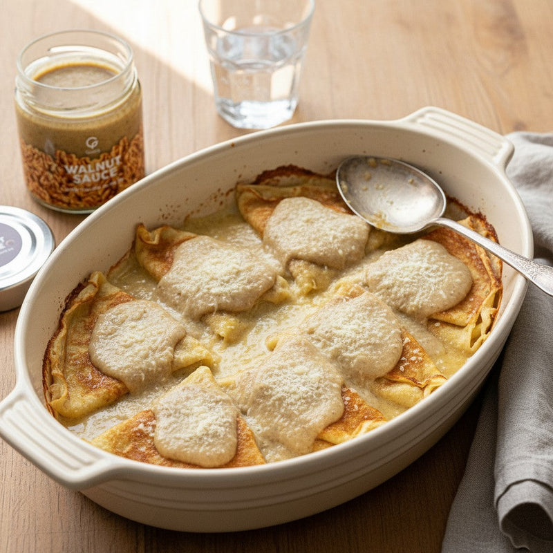 Crespelle alla Salsa di Noci baked in a dish, with the Gusta Walnut Sauce alongside