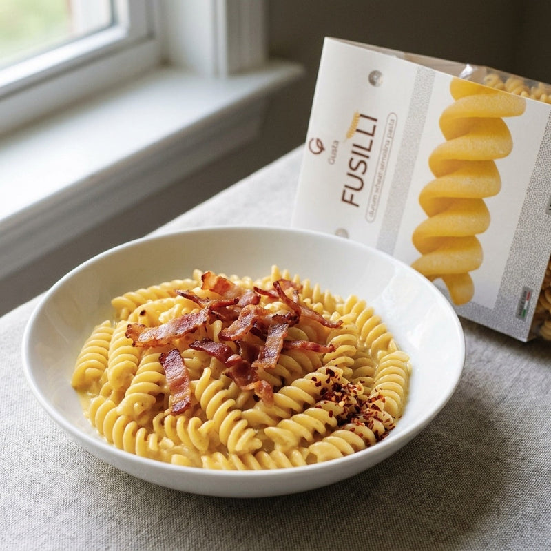 Fusilli con Panna, Speck e Zafferano plated, with Gusta Fusilli Pasta alongside