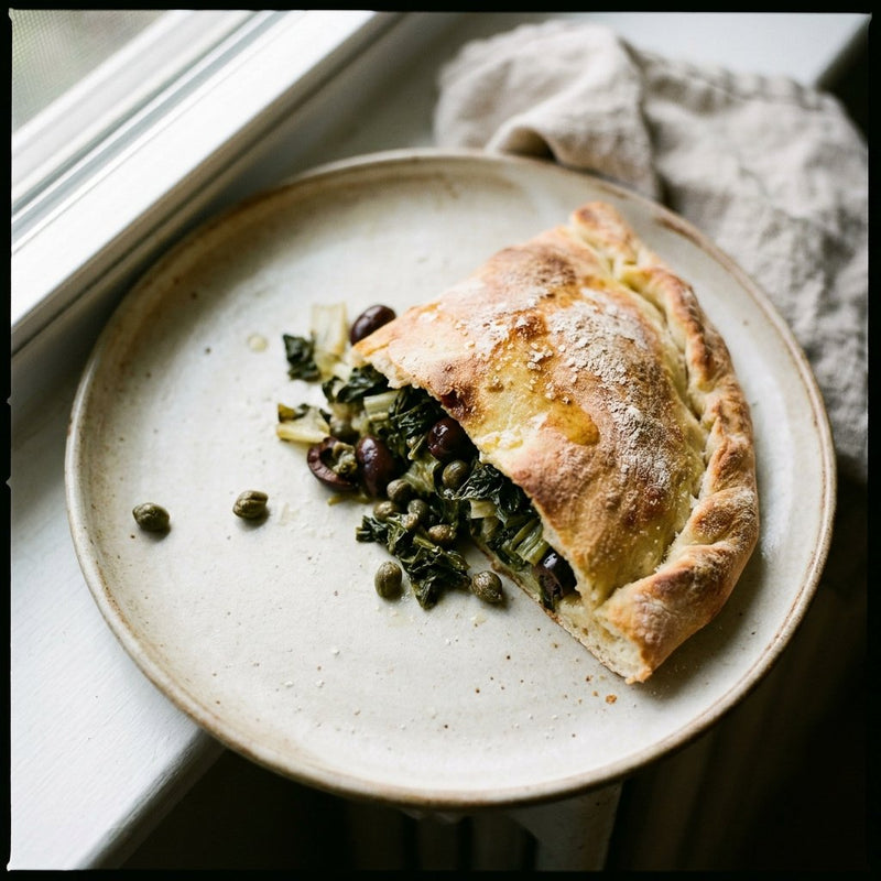Pizza di Scarola Napoletana sliced to show escarole filling