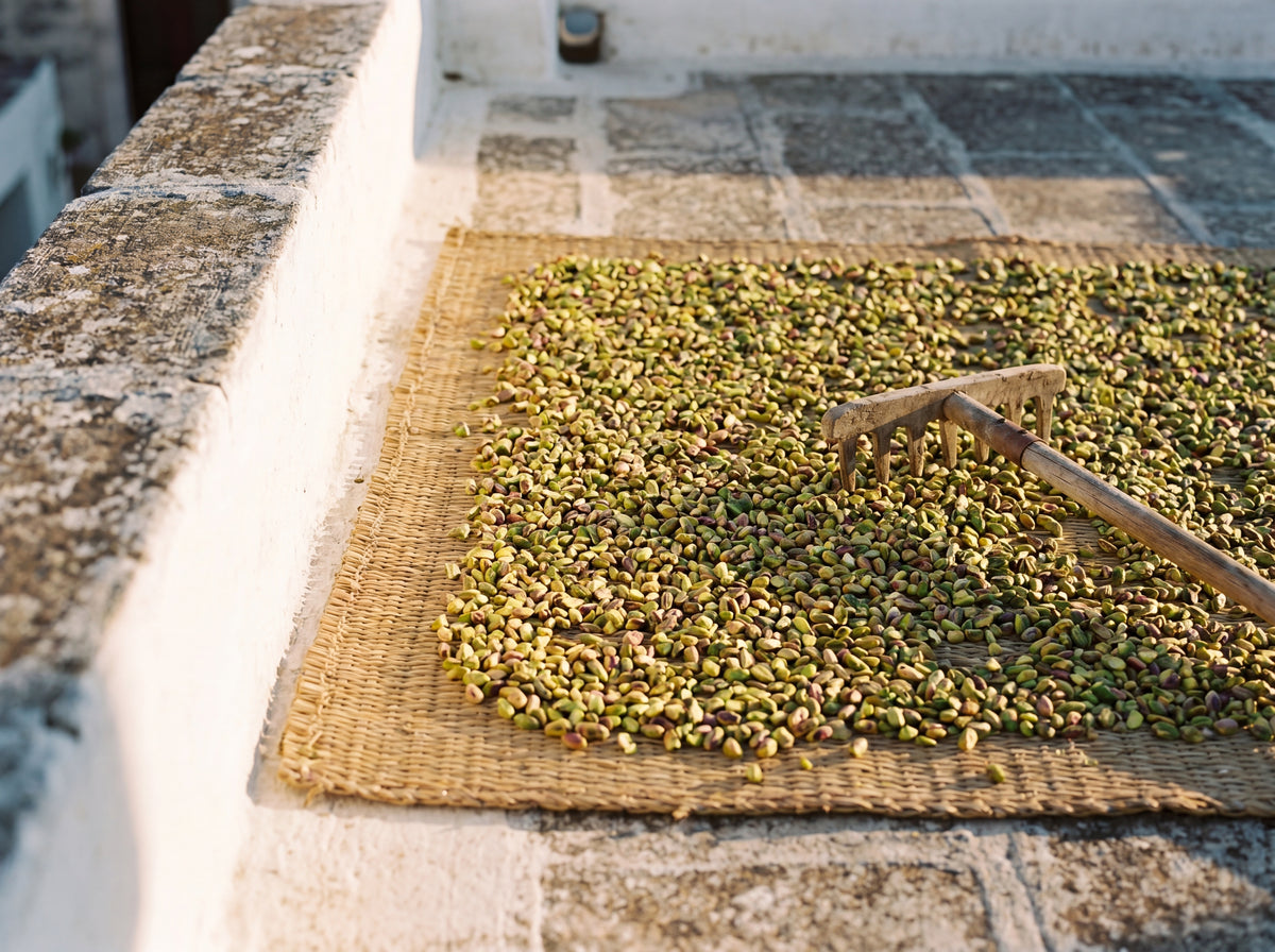 Pistachios drying on woven mat on whitewashed terrace, Sicilia